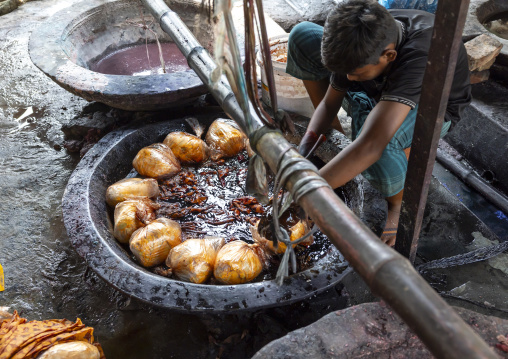Bangladeshi man dyeing fabrics in a batik factory, Chittagong Division, Comilla, Bangladesh
