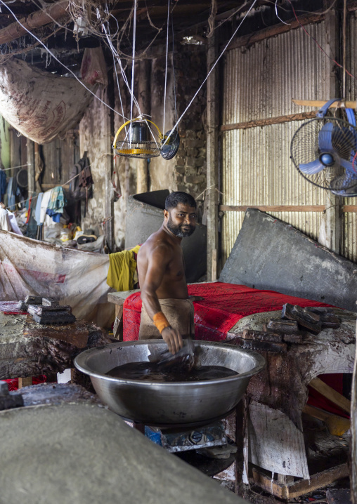 Bangladeshi man stamping wax on a cloth in a batik factory, Chittagong Division, Comilla, Bangladesh