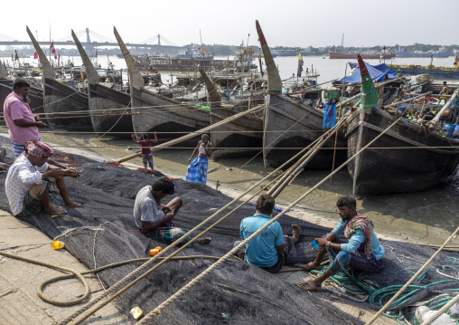 Bangladeshi men repairing fishing nets in the fish market, Chittagong Division, Chittagong, Bangladesh