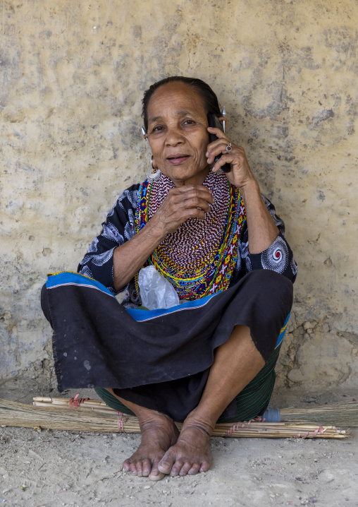 Tripura woman with necklaces and earrings calling on mobile phone, Chittagong Division, Rowangchhari, Bangladesh
