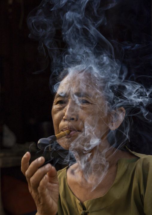 Marma woman smoking a cigar, Chittagong Division, Rowangchhari, Bangladesh