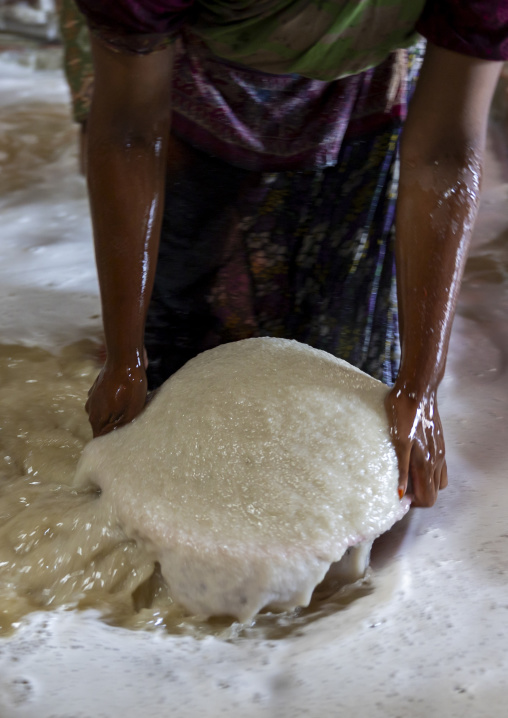 Bangladeshi woman washing salt in water in a factory, Chittagong Division, Chittagong, Bangladesh