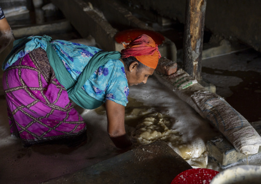 Bangladeshi woman washing salt in water in a factory, Chittagong Division, Chittagong, Bangladesh