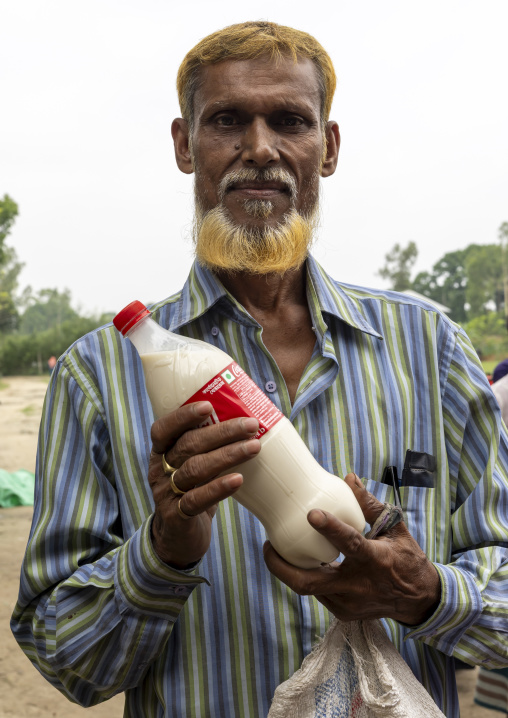 Bangladeshi farmer selling their fresh cow milk in the market, Dhaka Division, Dhamrai, Bangladesh