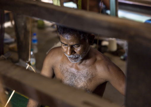 Bangladeshi man weaving in a sari factory, Dhaka Division, Delduar, Bangladesh