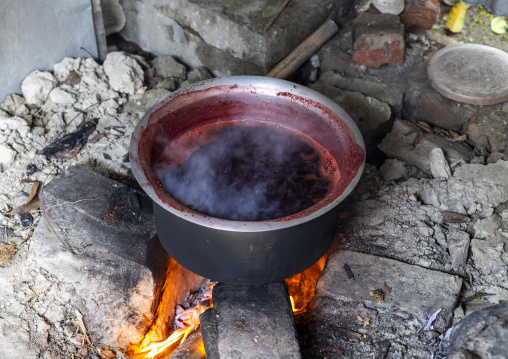 Bangladeshi man dyeing fabrics in red in Living Blue company, Rangpur Division, Goalpara, Bangladesh