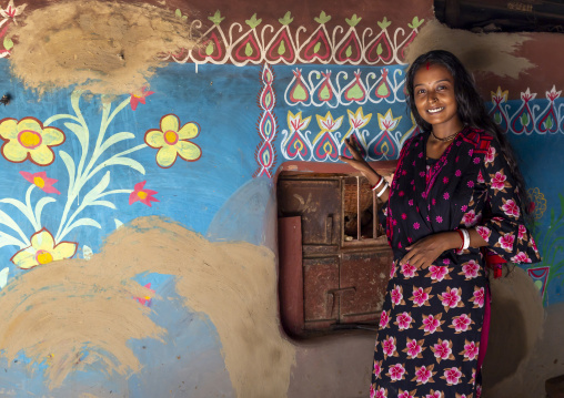 Bangladeshi teenage girl in front of a traditional wall painting in a house, Rajshahi Division, Tikoil, Bangladesh