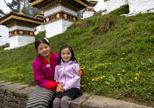 Butanese girls in Dochu La with 108 stupas or chortens, Punakha, Dochula Pass, Bhutan
