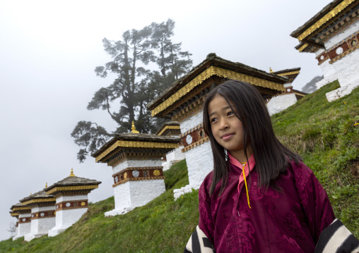 Butanese girl in Dochu La with 108 stupas or chortens, Punakha, Dochula Pass, Bhutan