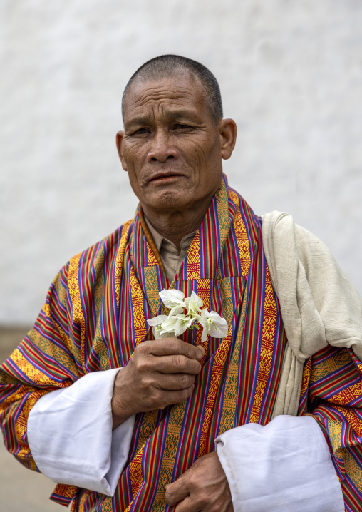 Bhutanese man with flowers in Punakha Dzong, Punakha dzongkhag, Punakha, Bhutan