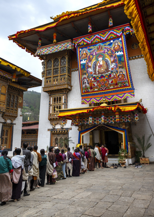 Bhutanese people queuing in Punakha dzong under a giant thangka, Punakha dzongkhag, Punakha, Bhutan
