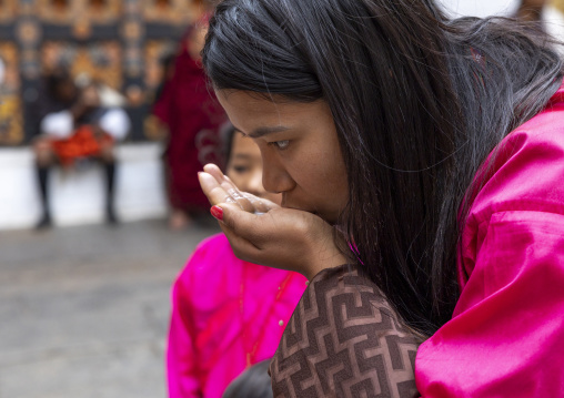 Bhutanese pilgrim eating black lentils with milk in Punakha Dzong, Punakha dzongkhag, Punakha, Bhutan