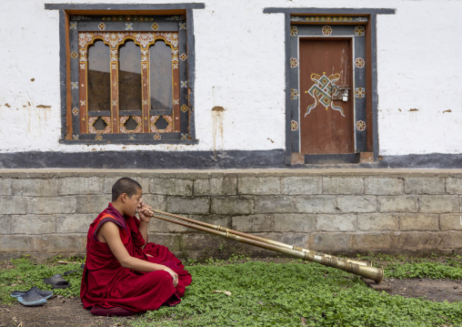 Bhutanese novices monks playing horns in Nyenzer Lhakhang, Thedtsho Gewog, Wangdue Phodrang, Bhutan