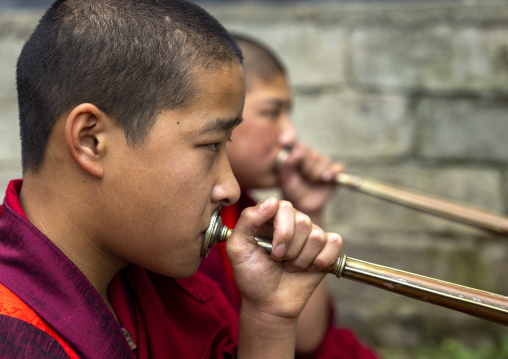 Bhutanese novices monks playing horns in Nyenzer Lhakhang, Thedtsho Gewog, Wangdue Phodrang, Bhutan