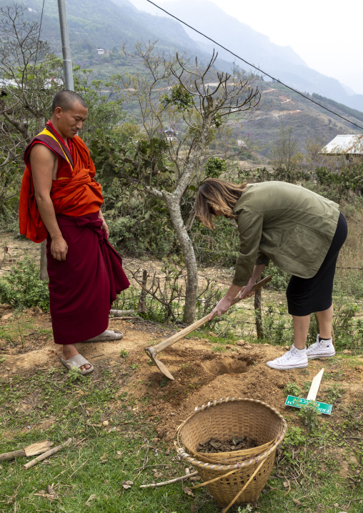 Western tourist planting a tree in Nyenzer Lhakhang, Thedtsho Gewog, Wangdue Phodrang, Bhutan