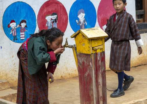 Bhutanese girl drinking tap water in Rubesa Primary School, Wangdue Phodrang, Rubesagewog, Bhutan