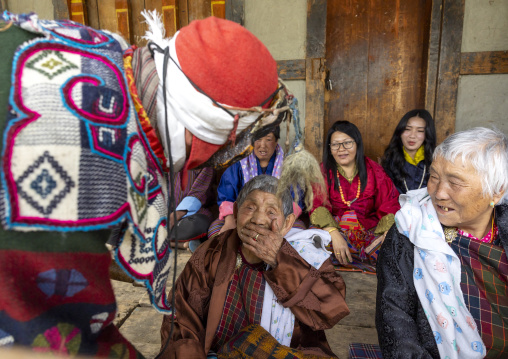 Masked atsara with women at Ura Yakchoe festival, Bumthang, Ura, Bhutan