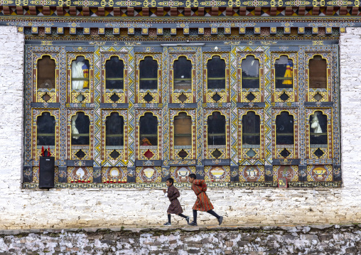 Bhutanese children running in Ura Lhakhang monastery, Bumthang, Ura, Bhutan