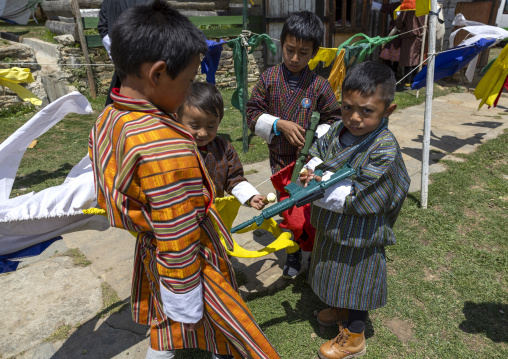Bhutanese boys with gun toys in Ura Yakchoe festival, Bumthang, Ura, Bhutan