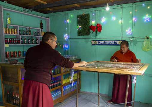 Bhutanese monks playing a table game in a bar, Chhoekhor Gewog, Bumthang, Bhutan