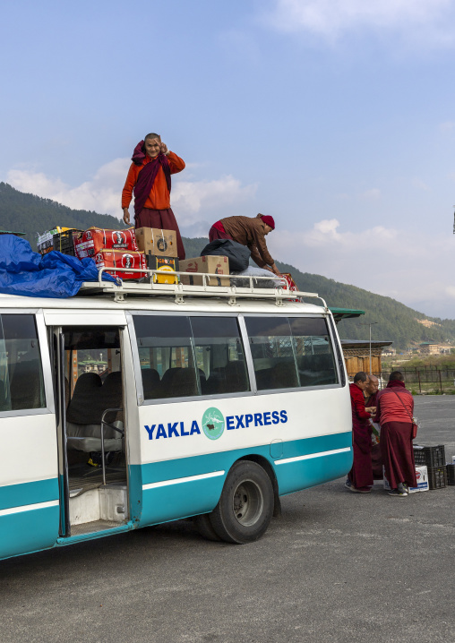 Monks loading boxes in a bus, Chhoekhor Gewog, Bumthang, Bhutan