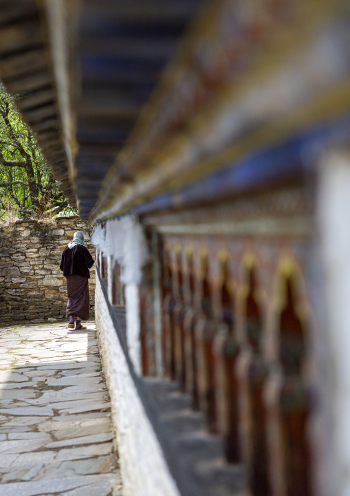 Bhutanese woman spiniing a prayer wheels in Ogyen Choling, Bumthang, Ogyen Choling, Bhutan