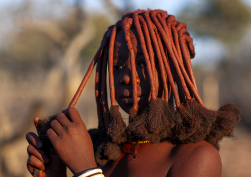 Young Himba tribe woman with traditional hairstyle, Omusati region, Ruacana, Namibia