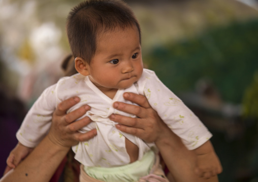 Mother holding her baby, Menglun, Yunnan province, China