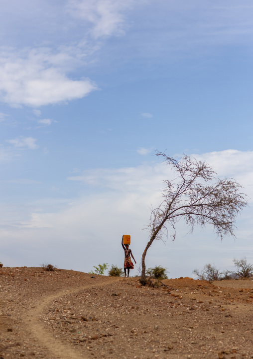 Mucubal tribe woman carrying water on her head, Namibe Province, Virei, Angola
