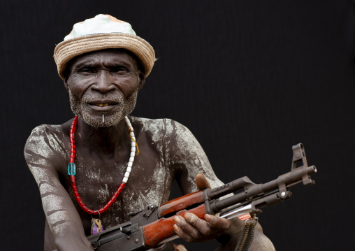 Karo man tribe with white painted chest and kalashnikov, Omo valley, Korcho, Ethiopia