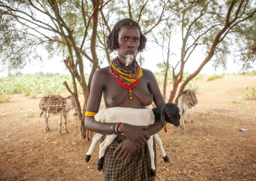 Dassanech tribe woman with baby sheep, Omo valley, Omorate, Ethiopia