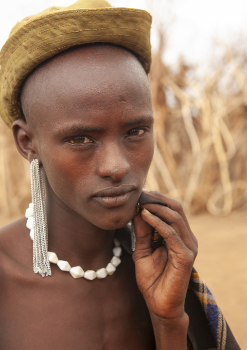Young Dassanech man with a hat portrait, Omo valley, Omorate, Ethiopia