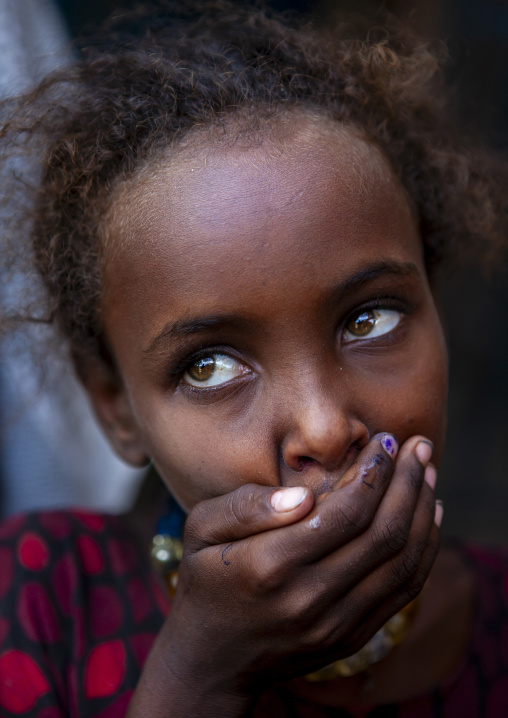 Afar tribe girl with hand on mouth, Afar Region, Assayta, Ethiopia