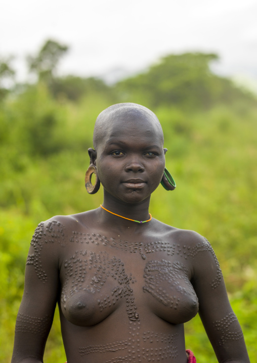 Surma woman with scarifications and enlarged ears, Omo valley, Kibish, Ethiopia