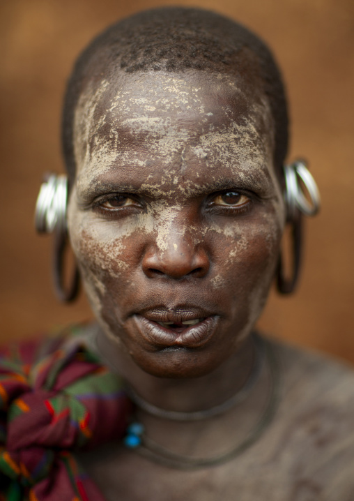 Suri tribe woman with an enlarged earlobe and painted face, Kibish, Omo valley, Ethiopia