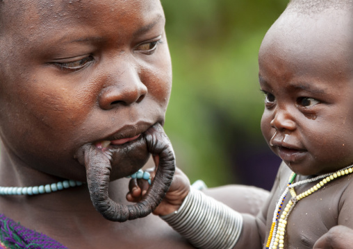 Suri tribe woman with enlarged lip and her baby, Kibish, Omo valley, Ethiopia
