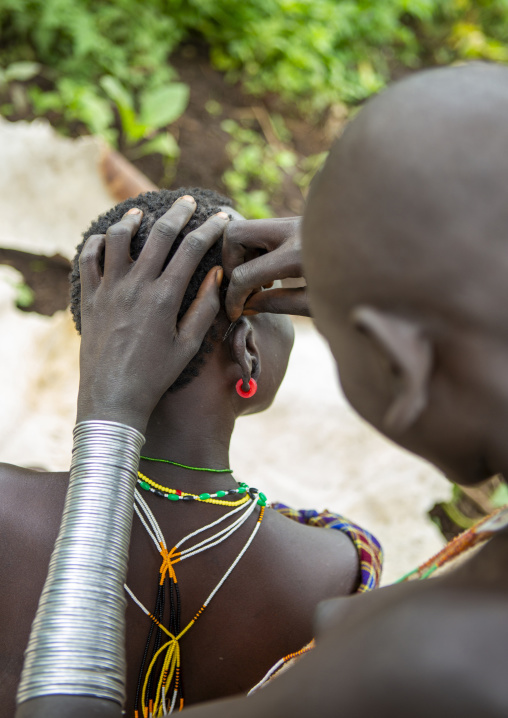 Suri tribe woman having a haircut, Kibish, Omo valley, Ethiopia