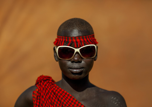 Bodi tribe young woman with sunglasses, Hana Mursi, Omo valley, Ethiopia