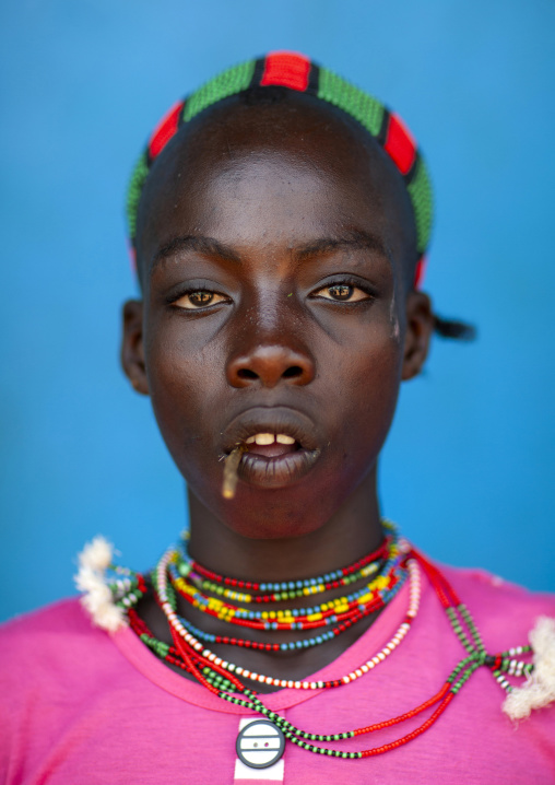 Hamer young man with a stick in his mouth, Dimeka, Omo valley, Ethiopia