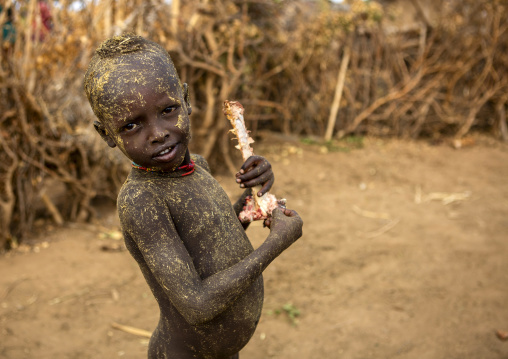 Dassanech tribe warriors sharing cow meat during a ceremony, Omorate, Omo valley, Ethiopia