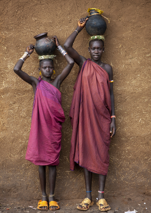 Bodi tribe women carrying jars of milk on their head, Hana Mursi, Omo valley, Ethiopia