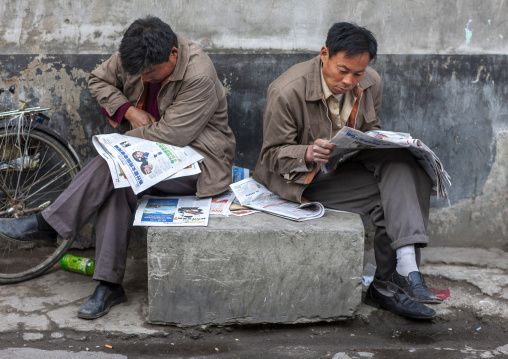 Men reading newspapers in the  street, Tongzhou District, Beijing, China