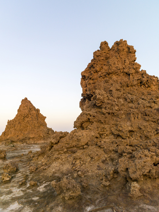 Two limestone chimney rock formations rise from the desert at dusk, Afar depression, Lake Abbe, Djibouti