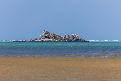 A small rocky islet sits in a turquoise sea, Obock Region, Khor angar, Djibouti