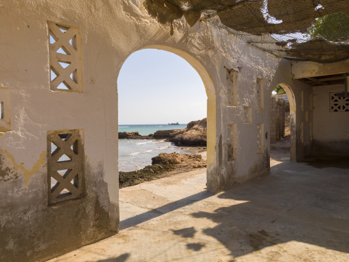 Crumbling arches of a restaurant destroyed in the civil war frame a view of the sea, Obock Region, Obock, Djibouti