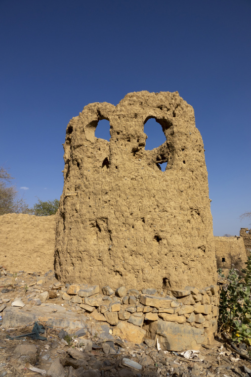 Ruined mudbrick tower with two heart-shaped openings standing against a clear blue sky, Ad Dakhiliyah Region, Al Hamra, Oman