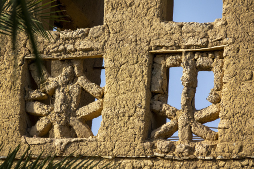 Close-up of a carved mudbrick lattice window framed by a weathered wooden lintel, Ad Dakhiliyah Region, Al Hamra, Oman