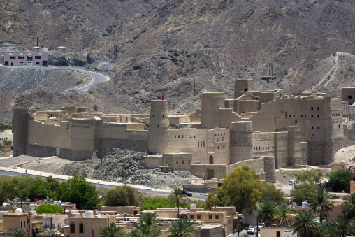 Telephoto view of Bahla Fort's mudbrick towers and walls set against the mountains, Ad Dakhiliyah Governorate, Bahla, Oman