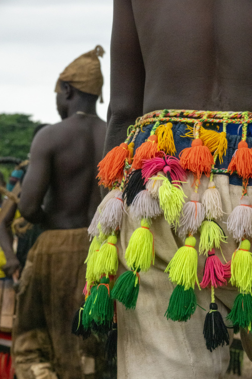 A shirtless Senufo man dances the Ngoro wearing a tasseled ceremonial skirt during a ceremony, Savanes district, Ndara, Ivory Coast