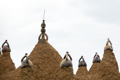 An ornate ceramic finial with graduated rings crowns a spire of the 17th-century Sudano-Sahelian mosque, Savanes district, Kouto, Ivory Coast
